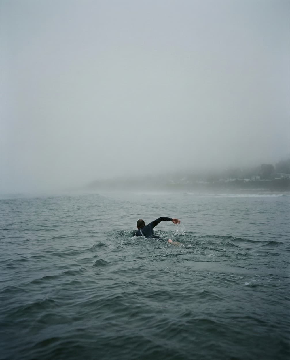 Пловец в тумане плывёт к едва видимому берегу